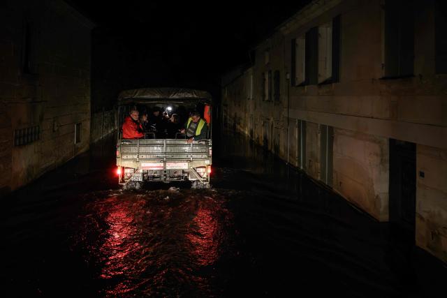 A French gendarmerie 4x4 vehicle transporting residents drives in the flood-isolated village of Courcoury, south-western France on February 23, 2026, towards neighboring Courpignac as the Charente-Maritime commune remains surrounded by floodwaters following storm Nils. (Photo by Philippe LOPEZ / AFP)