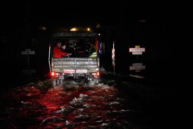 Students and adults transported from the flood-isolated village of Courcoury sit aboard a French Gendarmerie 4x4 vehicle upon arrival in Courpignac, south-western France on February 23, 2026, as authorities organize daily transport between the two Charente-Maritime communes following severe flooding from storm Nils that left Courcoury surrounded by water. (Photo by Philippe LOPEZ / AFP)
