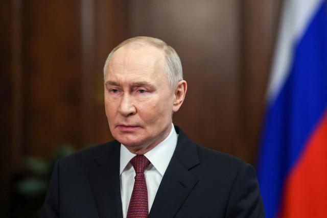 In this pool photograph distributed by the Russian state agency Sputnik, Russia's President Vladimir Putin makes a video address to congratulate veterans, military and civilian personnel of the Armed Forces and all citizens of Russia on Defender of the Fatherland Day in Moscow on February 23, 2026. (Photo by VYACHESLAV PROKOFYEV / POOL / AFP)