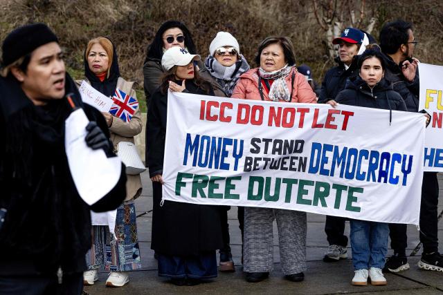 People demonstrate in support of former Philippines' president Rodrigo Duterte outside the International Criminal Court (ICC) where he will be questioned on charges of crimes against humanity, in The Hague on February 23, 2026. As the 80-year-old will not be present at the hearing after the court granted a defence request to waive his right to appear, despite judges ruling that he was fit to take part, the "confirmation of charges" hearing, taking place over four days, will determine whether there is enough evidence against Duterte to proceed to a trial. (Photo by Ramon van Flymen / ANP / AFP) / Netherlands OUT