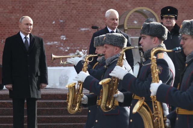 In this pool photograph distributed by the Russian state agency Sputnik, Russia's President Vladimir Putin (L) and Russia's Defence Minister Andrei Belousov (2nd L) attend a wreath-laying ceremony at the Tomb of the Unknown Soldier by the Kremlin Wall to mark Defender of the Fatherland Day in Moscow on February 23, 2026. (Photo by Sergey FADEICHEV / POOL / AFP)