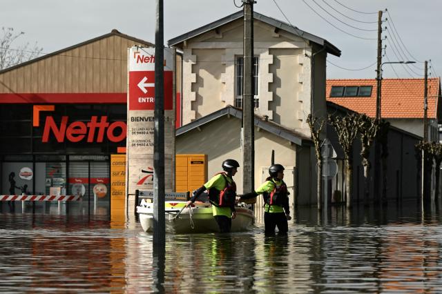 Members of the Red Cross pull a boat on a flooded street has they provide assistance to residents following severe flooding from storm Nils in Saintes, south-western France, on February 23, 2026. (Photo by Philippe LOPEZ / AFP)