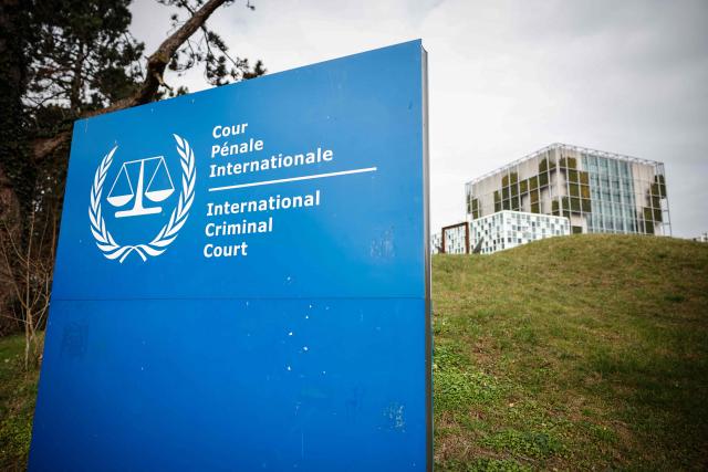 This photograph shows the "the International Criminal Court (ICC)" in the background with its logo on a sign in the foreground in The Hague, on February 23, 2026. (Photo by Simon Wohlfahrt / AFP)