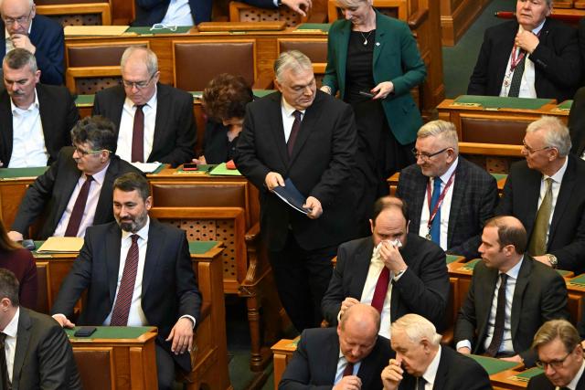Hungarian Prime Minister Viktor Orban (C) arrives prior to the spring session of the Hungarian Parliament in Budapest, Hungary, on February 23, 2026. The nationalist leader is facing the toughest challenge since returning to power in 2010, with his Fidesz party trailing the opposition TISZA party in opinion polls ahead of parliamentary elections on April 12, 2026. (Photo by Attila KISBENEDEK / AFP)