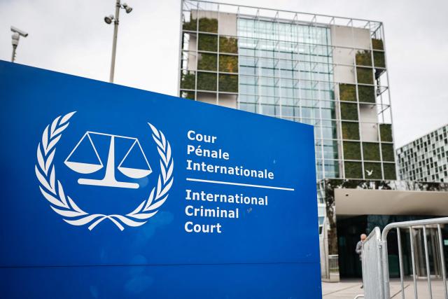 This photograph shows the "the International Criminal Court (ICC)" in the background with its logo on a sign in the foreground in The Hague, on February 23, 2026. (Photo by Simon Wohlfahrt / AFP)