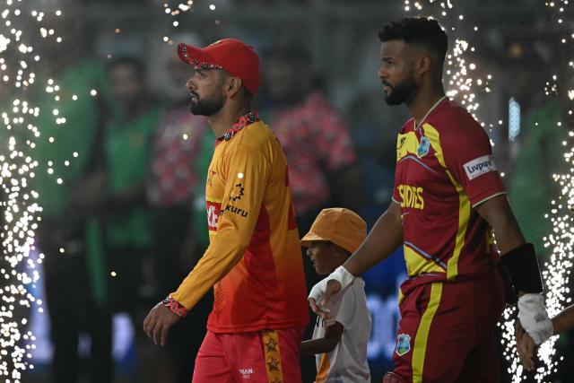 Zimbabwe's captain Sikandar Raza (L) and West Indies' captain Shai Hope (R) arrive for the national anthem during the 2026 ICC Men's T20 Cricket World Cup Super Eights match between West Indies and Zimbabwe at the Wankhede Stadium in Mumbai on February 23, 2026. (Photo by Punit PARANJPE / AFP)