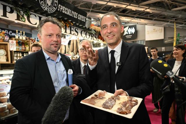 Co-president of French center-left party Place publique (PP) Raphael Glucksmann (R) visits a Corsican food booth at the International Agricultural Show (Salon de l'Agriculture) at Paris Expo Porte de Versailles in Paris on February 23, 2026. (Photo by Bertrand GUAY / AFP)