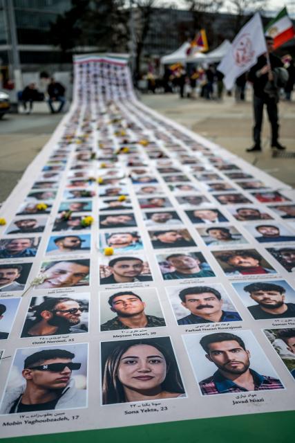 Portraits of killed Iranian protesters are displayed during a demonstration against the Iranian regime on the sideline of the 61st session of the UN Human Rights Council in Geneva on February 23, 2026. (Photo by Fabrice COFFRINI / AFP)