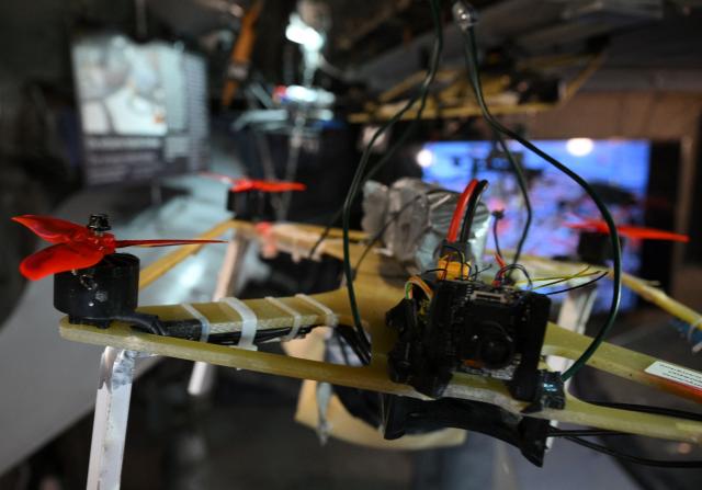 A Russian FPV combat drone with red propellers is on display during a press presentation of the "Ukraine Museum" in the "Berlin Story Bunker" on February 23, 2026 in Berlin, one day before the exhibition's opening to the public and the fourth anniversary of Russia's invasion in Ukraine. Covering 300 square meters, the former World War II bunker in Berlin's Story Bunker will display various Russian combat drones and a destroyed Ukrainian evacuation vehicle. (Photo by RALF HIRSCHBERGER / AFP)