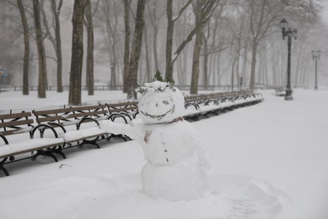 A snowman is seen in a snow covered park during a winter storm in the Brooklyn borough of New York City on February 23, 2026. New York ordered drivers off the road and shut down schools on Monday, while residents hunkered down for a massive snowstorm hitting the United States northeast. The National Weather Service (NWS) said in a post on X that "heavy snow is still falling" at 5:28 am local time (1028 GMT) on Monday adding that a the total snowfall stands at 14.9 inches. (Photo by ANGELA WEISS / AFP)