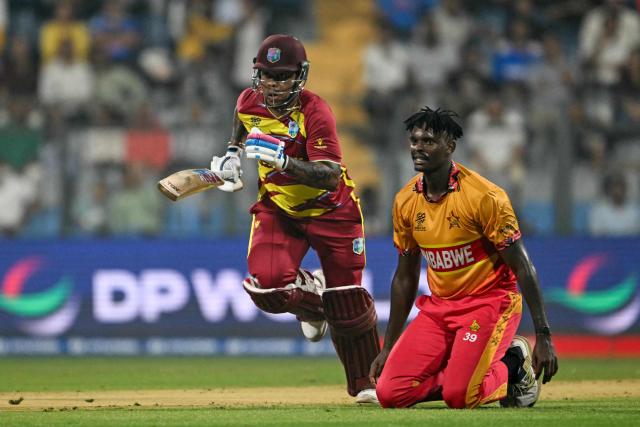 West Indies' Shimron Hetmyer (L) runs between the wickets as Zimbabwe's Richard Ngarava looks on during the 2026 ICC Men's T20 Cricket World Cup Super Eights match between West Indies and Zimbabwe at the Wankhede Stadium in Mumbai on February 23, 2026. (Photo by Indranil MUKHERJEE / AFP)