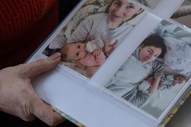 Nina, mother of fallen Ukrainian soldier Yuriy Glodan, shows photos of her son's family, killed in a missile attack, in Odesa on February 20, 2026. It had been a sunny Saturday in Ukraine's southern city of Odesa on April 23, 2022. Despite two months of war, the Glodan family wanted to mark Easter together. But a Russian missile struck their building, killing three-month-old Kira, her mother, 28-year-old Valeria, and her 54-year-old grandmother Lyudmyla. (Photo by Oleksandr GIMANOV / AFP)