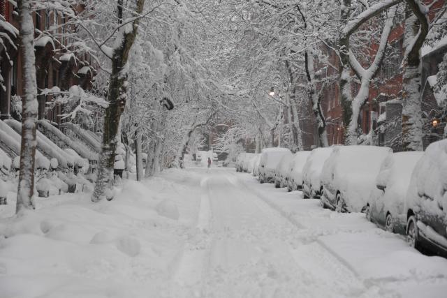 A snow covered street is seen during a winter storm in the Brooklyn borough of New York City on February 23, 2026. New York ordered drivers off the road and shut down schools on Monday, while residents hunkered down for a massive snowstorm hitting the United States northeast. The National Weather Service (NWS) said in a post on X that "heavy snow is still falling" at 5:28 am local time (1028 GMT) on Monday adding that a the total snowfall stands at 14.9 inches. (Photo by ANGELA WEISS / AFP)