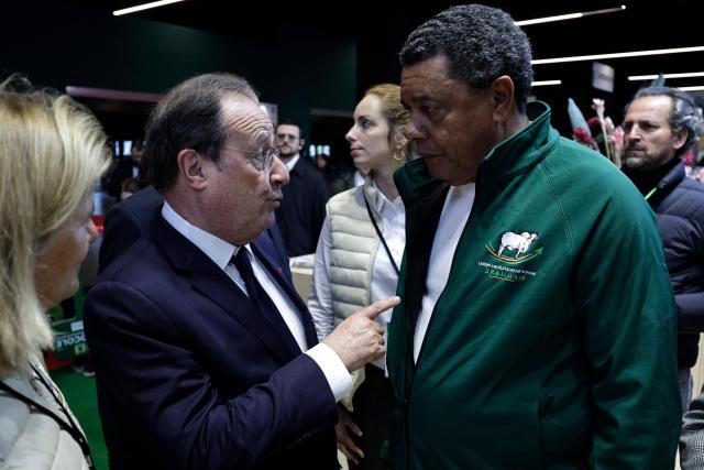 Socialistes et Apparentes' MP Francois Hollande (L) speaks to French Brahman cattle breeder from Martinique Andre Prosper as he visits the Paris International Agricultural Show (Salon de l'Agriculture) at Paris Expo Porte de Versailles in Paris on February 23, 2026. (Photo by STEPHANE DE SAKUTIN / AFP)