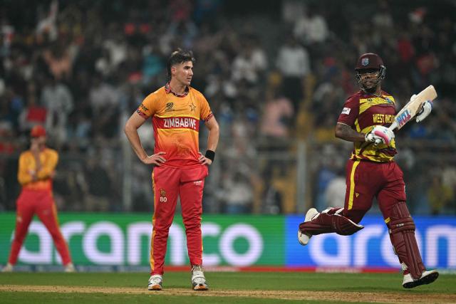 Zimbabwe's Brad Evans (C) looks on as West Indies' Shimron Hetmyer (R) takes a run during the 2026 ICC Men's T20 Cricket World Cup Super Eights match between West Indies and Zimbabwe at the Wankhede Stadium in Mumbai on February 23, 2026. (Photo by Punit PARANJPE / AFP)