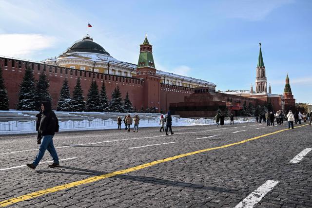 People walk on Red Square in central Moscow during the Defender of the Fatherland Day on February 23, 2026. (Photo by Hector RETAMAL / AFP)