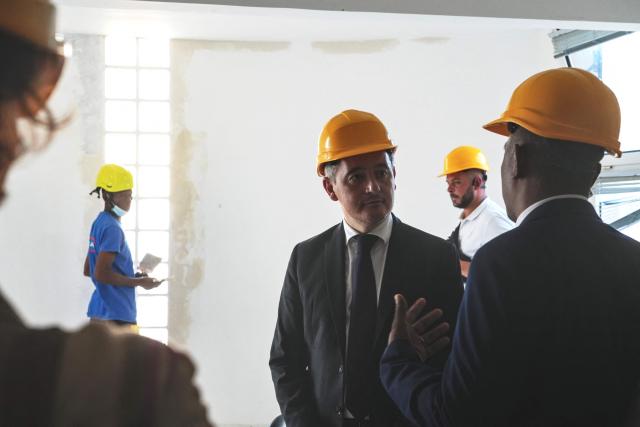 French Minister of Justice Gerald Darmanin (C) listens as he visits the renovation works at the Mamoudzou courthouse, in Mamoudzou, on the French Indian Ocean territory of Mayotte, on February 23, 2026. (Photo by Marine GACHET / AFP)