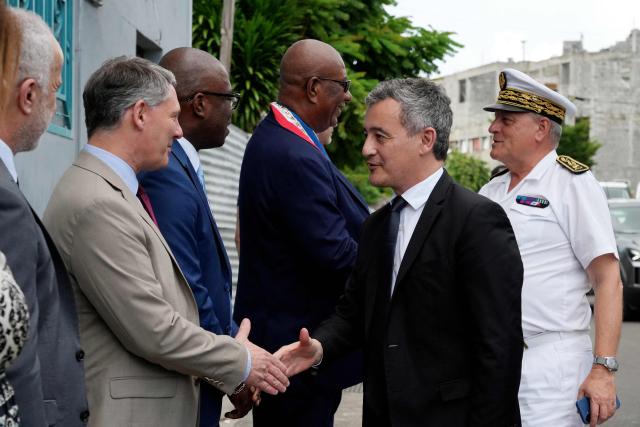 French Minister of Justice, Gerald Darmanin (C) greets officials as he arrives at the new open-environment educational unit, in Pamandzi, on the French Indian Ocean territory of Mayotte, on February 23, 2026. (Photo by Marine GACHET / AFP)