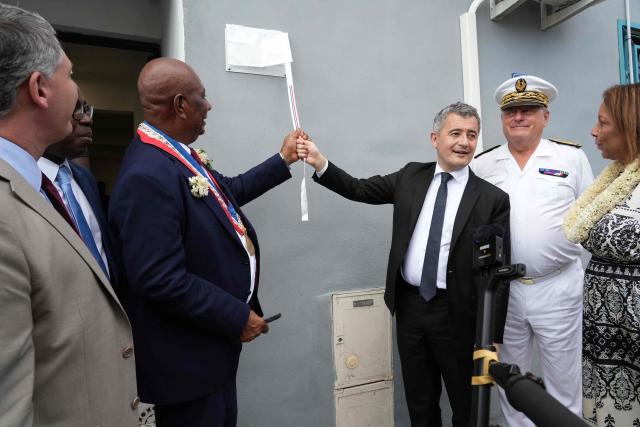 French Minister of Justice, Gerald Darmanin (3rdR), and Pamandzi Mayor, Madi Madi Souf (2ndL), unveil a plaque as they inaugurate the new open-environment educational unit, in Pamandzi, on the French Indian Ocean territory of Mayotte, on February 23, 2026. (Photo by Marine GACHET / AFP)