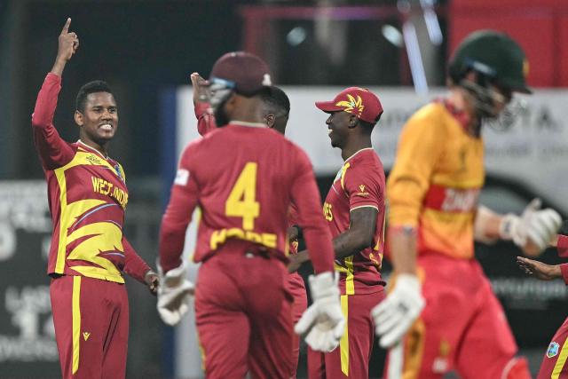 West Indies' Akeal Hosein (L) celebrates after taking wicket of Zimbabwe's Brian Bennett (L) during the 2026 ICC Men's T20 Cricket World Cup Super Eights match between West Indies and Zimbabwe at the Wankhede Stadium in Mumbai on February 23, 2026. (Photo by Punit PARANJPE / AFP)