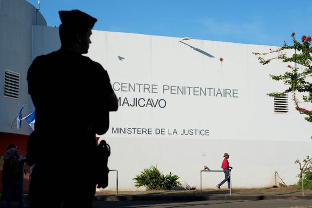 A police officer stands in front of the Majicavo Correctional Center in the village of Majicavo Lamir, in the township of Koungou, on the French Indian Ocean territory of Mayotte, on February 23, 2026. (Photo by Marine GACHET / AFP)