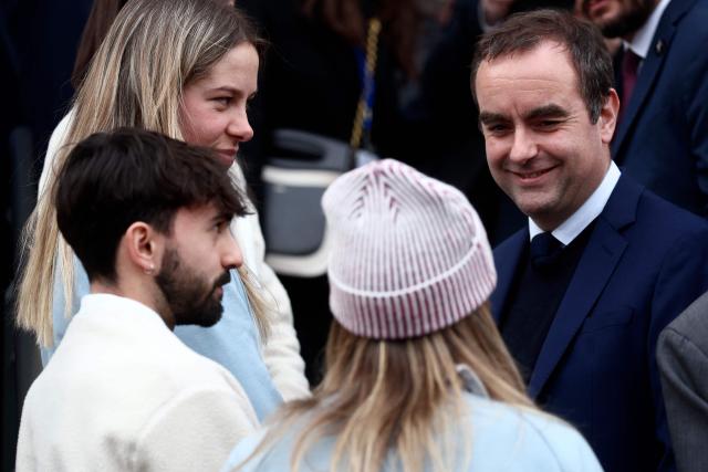 France's Prime Minister Sebastien Lecornu (L) greets athletes, including France's Marie Lamure, during a ceremony of arrival of the Olympic flag marking the handover from Milano Cortina 2026 to French Alps 2030 Winter Olympic Games, in the French Alps in Albertville, south-eastern France on February 23, 2026. (Photo by Alex MARTIN / AFP)