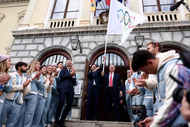 The president of the Rhone-Alpes region Fabrice Pannekoucke (C-L) and  Provence-Alpes-Côte d'Azur region president Renaud Muselier (C-R) wave the Olympic flag during a ceremony of arrival of the Olympic flag marking the handover from Milano Cortina 2026 to French Alps 2030 Winter Olympic Games, in the French Alps in Albertville, south-eastern France on February 23, 2026. (Photo by Alex MARTIN / AFP)