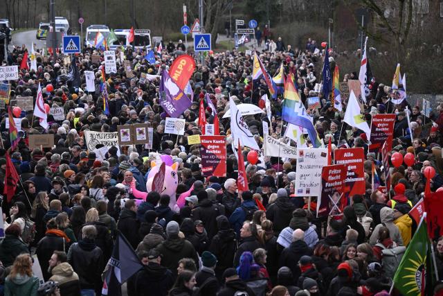 An overview shows protesters hold placards and flags during a demonstration against the new year's reception of the far-right Alternative for Germany (AfD) party, on February 23, 2026 in Dusseldorf, western Germany. (Photo by INA FASSBENDER / AFP)