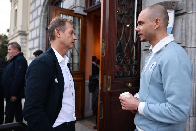 Former Olympic skiing champion and President of the Coordination Commission for the 2030 Winter Olympics Edgar Grospiron talks to biathlete Emilien Jacquelin (R) during a ceremony of arrival of the Olympic flag marking the handover from Milano Cortina 2026 to French Alps 2030 Winter Olympic Games, in the French Alps in Albertville, south-eastern France on February 23, 2026. (Photo by Alex MARTIN / AFP)