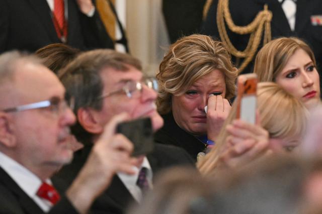 Guests react as US President Donald Trump speaks during the Angel Families Remembrance Ceremony in the East Room of the White House in Washington, DC, on February 23, 2026. (Photo by SAUL LOEB / AFP)