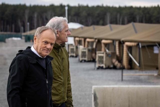 Poland's Prime Minister Donald Tusk (L) and Norway's Prime Minister Jonas Gahr Store are pictured during their meeting on February 23, 2026, in Camp Jomsborg - Norwegian Army training camp located in Lipa, south-eastern Poland, established to train Ukrainian soldiers. (Photo by Wojtek RADWANSKI / AFP)