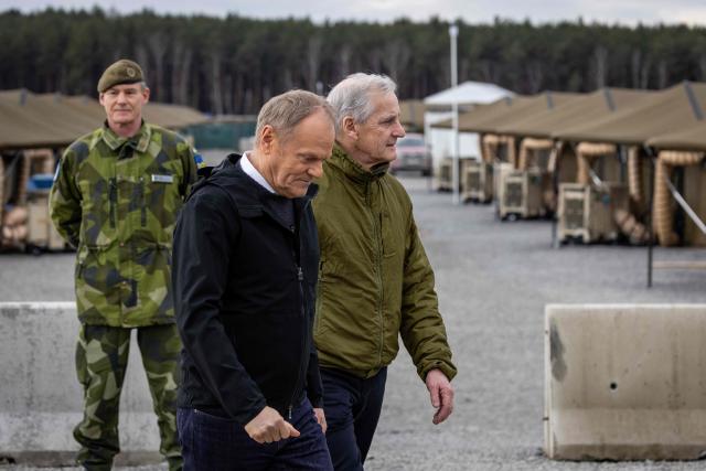 Poland's Prime Minister Donald Tusk (L) and Norway's Prime Minister Jonas Gahr Store are pictured during their meeting on February 23, 2026, in Camp Jomsborg - Norwegian Army training camp located in Lipa, south-eastern Poland, established to train Ukrainian soldiers. (Photo by Wojtek RADWANSKI / AFP)