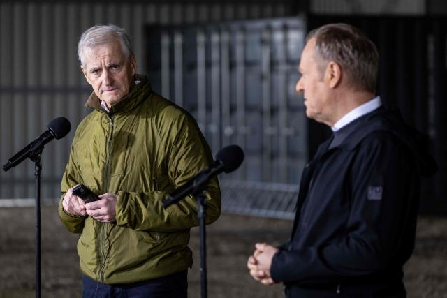 Norway's Prime Minister Jonas Gahr Store (L) speaks as Poland's Prime Minister Donald Tusk listens during a press conference on February 23, 2026, in Camp Jomsborg - Norwegian Army training camp located in Lipa, south-eastern Poland, established to train Ukrainian soldiers. (Photo by Wojtek RADWANSKI / AFP)
