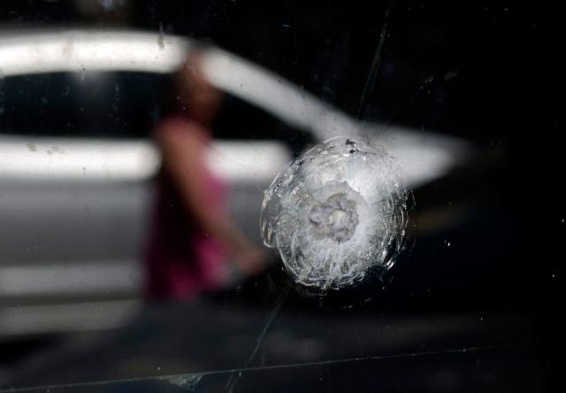 View of a bullet inpact on the window of a police station in Guadalajara, Jalisco, Mexico, on February 23, 2026, a day after clashes. Mexico has deployed 10,000 troops to quell clashes sparked by the killing of the country's most-wanted drug lord, Nemesio "El Mencho" Oseguera, leader of the Jalisco New Generation Cartel (CJNG), that have claimed dozens of lives, officials said on February 23. News of his death triggered spasms of violence, with cartel members blocking roads in 20 states and torching vehicles and businesses. (Photo by Ulises RUIZ / AFP)