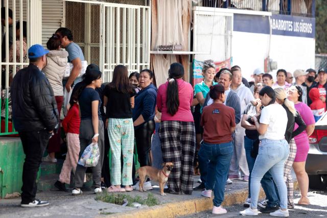 People wait in line outside a tortilla store a day after it was closed due to clashes in Guadalajara, Jalisco, Mexico, on February 23, 2026. Mexico has deployed 10,000 troops to quell clashes sparked by the killing of the country's most-wanted drug lord, Nemesio "El Mencho" Oseguera, leader of the Jalisco New Generation Cartel (CJNG), that have claimed dozens of lives, officials said on February 23. News of his death triggered spasms of violence, with cartel members blocking roads in 20 states and torching vehicles and businesses. (Photo by Ulises RUIZ / AFP)