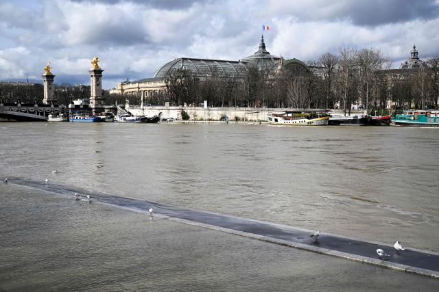 This photograph shows the flooded banks of the Seine river with the Pont de l'Alma and the Grand Palais in the background, in Paris on February 23, 2026. (Photo by Anna KURTH / AFP)