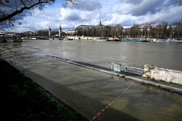 This photograph shows the flooded banks of the Seine river with the Pont de l'Alma and the Grand Palais in the background, in Paris on February 23, 2026. (Photo by Anna KURTH / AFP)