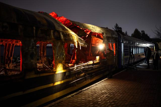Members of the media view a Ukrainian railway carriage that was attacked by a Russian drone on January 27, 2026 near Kharkiv in eastern Ukraine killing six people, on display at the Kyiv central train station on February 23, 2026, ahead of the fourth anniversary of Russia's invasion of Ukraine. Russia launched its full-scale invasion of Ukraine on February 24, 2022, unleashing the deadliest war in Europe since World War II. (Photo by HENRY NICHOLLS / AFP)