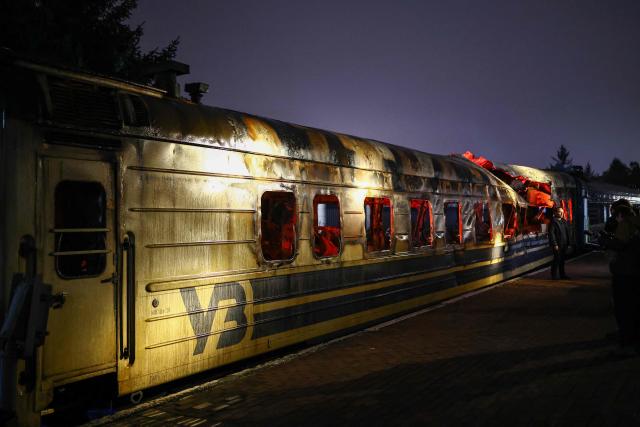 Members of the media view a Ukrainian railway carriage that was attacked by a Russian drone on January 27, 2026 near Kharkiv in eastern Ukraine killing six people, on display at the Kyiv central train station on February 23, 2026, ahead of the fourth anniversary of Russia's invasion of Ukraine. Russia launched its full-scale invasion of Ukraine on February 24, 2022, unleashing the deadliest war in Europe since World War II. (Photo by HENRY NICHOLLS / AFP)
