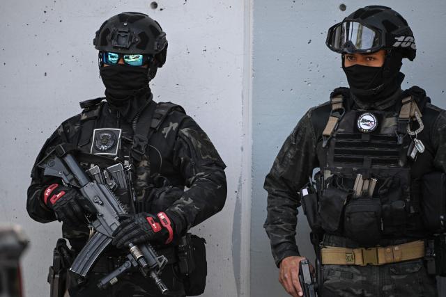 Members of Mexico's National Guard special forces stand guard around the headquarters of the Specialized Prosecutor's Office for Organized Crime (FEMDO) in Mexico City on February 23, 2026. Mexico has deployed 10,000 troops to quell clashes sparked by the killing of the country's most wanted drug lord, which have left dozens dead, officials said on February 23. Nemesio "El Mencho" Oseguera, leader of the Jalisco New Generation Cartel (CJNG), was wounded on February 22 in a shootout with soldiers in the town of Tapalpa in Jalisco state and died while being flown to Mexico City, the army said. (Photo by Yuri CORTEZ / AFP)