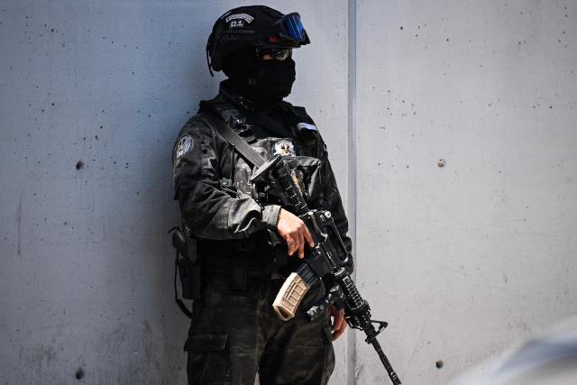 A member of Mexico's National Guard special forces stands guard around the headquarters of the Specialized Prosecutor's Office for Organized Crime (FEMDO) in Mexico City on February 23, 2026. Mexico has deployed 10,000 troops to quell clashes sparked by the killing of the country's most wanted drug lord, which have left dozens dead, officials said on February 23. Nemesio "El Mencho" Oseguera, leader of the Jalisco New Generation Cartel (CJNG), was wounded on February 22 in a shootout with soldiers in the town of Tapalpa in Jalisco state and died while being flown to Mexico City, the army said. (Photo by Yuri CORTEZ / AFP)