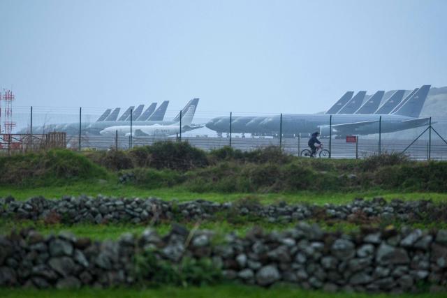 A cyclist passes in front of at least fifteen US Airforce KC-46 Pegasus tankers and one P-8 Poseidon tankers from the US Navy which are stationed at Lajes Air Base, Praia da Vitória, Terceira island, in the Azores archipielago in the Atlantic Ocean on February 23, 2026. Amid tensions with Iran, the United States has intensified its use of the Lajes air base in the Azores. The two countries are scheduled to resume their diplomatic talks on Thursday. (Photo by ANTONIO ARAUJO / AFP)