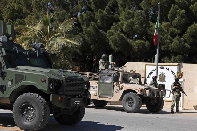 Soldiers from the Mexican Army guard the facilities of the Military Garrison in Ciudad Juarez, Chihuahua state, Mexico, on February 23, 2026. Mexico has deployed 10,000 troops to quell clashes sparked by the killing of the country's most wanted drug lord, which have left dozens dead, officials said on February 23. Nemesio "El Mencho" Oseguera, leader of the Jalisco New Generation Cartel (CJNG), was wounded on February 22 in a shootout with soldiers in the town of Tapalpa in Jalisco state and died while being flown to Mexico City, the army said. (Photo by Herika Martinez / AFP)