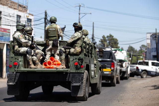 Members of the Mexican Army patrol the MoreliaPatzcuaro Highway to prevent vehicle fires and road blockades in Michoacan state, Mexico, on February 23, 2026. Mexico has deployed 10,000 troops to quell clashes sparked by the killing of the country's most wanted drug lord, which have left dozens dead, officials said on February 23. Nemesio "El Mencho" Oseguera, leader of the Jalisco New Generation Cartel (CJNG), was wounded on February 22 in a shootout with soldiers in the town of Tapalpa in Jalisco state and died while being flown to Mexico City, the army said. (Photo by Enrique Castro / AFP)