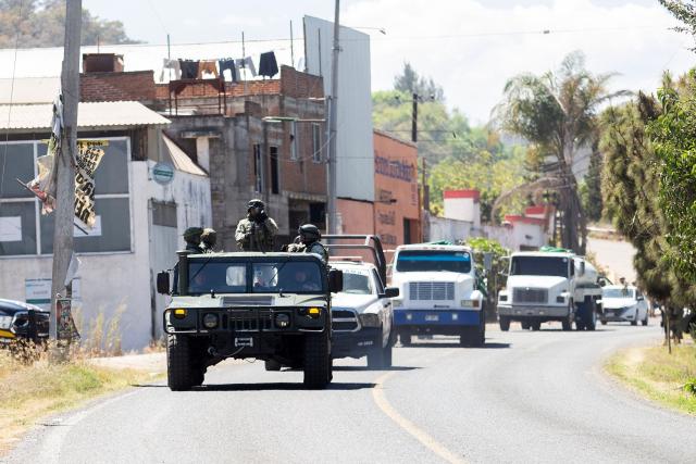 Members of the Mexican Army patrol the MoreliaPatzcuaro Highway to prevent vehicle fires and road blockades in Michoacan state, Mexico, on February 23, 2026. Mexico has deployed 10,000 troops to quell clashes sparked by the killing of the country's most wanted drug lord, which have left dozens dead, officials said on February 23. Nemesio "El Mencho" Oseguera, leader of the Jalisco New Generation Cartel (CJNG), was wounded on February 22 in a shootout with soldiers in the town of Tapalpa in Jalisco state and died while being flown to Mexico City, the army said. (Photo by Enrique Castro / AFP)