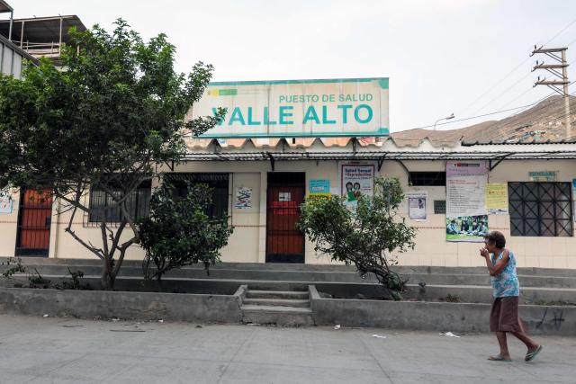 A woman walks past the Valle Alto health centre in Lima on February 23, 2026. Peru will hold a presidential election on April 12, 2026. (Photo by Connie FRANCE / AFP)