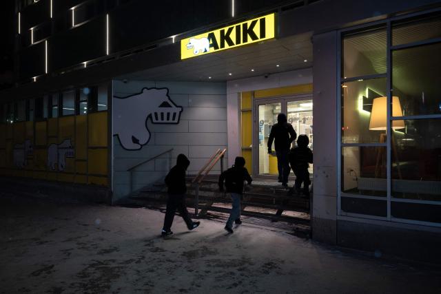 Young people run to take shelter in a supermarket during snowfall in Nuuk, Greenland, on February 23, 2026. (Photo by Florent VERGNES / AFP)