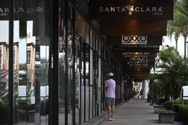 A man stands in front of closed shops in Puerto Vallarta, Jalisco state, Mexico, on February 23, 2026. Mexico has deployed 10,000 troops to quell clashes sparked by the killing of the country's most wanted drug lord, which have left dozens dead, officials said on February 23. Nemesio "El Mencho" Oseguera, leader of the Jalisco New Generation Cartel (CJNG), was wounded on February 22 in a shootout with soldiers in the town of Tapalpa in Jalisco state and died while being flown to Mexico City, the army said. (Photo by Alfredo ESTRELLA / AFP)