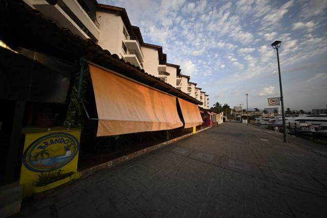 Closed shops and restaurants are seen in Puerto Vallarta, Jalisco state, Mexico, on February 23, 2026. Mexico has deployed 10,000 troops to quell clashes sparked by the killing of the country's most wanted drug lord, which have left dozens dead, officials said on February 23. Nemesio "El Mencho" Oseguera, leader of the Jalisco New Generation Cartel (CJNG), was wounded on February 22 in a shootout with soldiers in the town of Tapalpa in Jalisco state and died while being flown to Mexico City, the army said. (Photo by Alfredo ESTRELLA / AFP)
