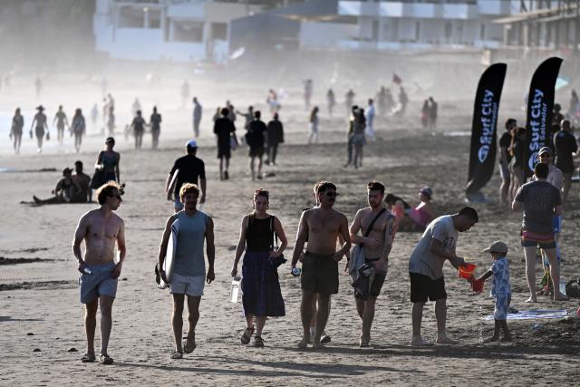 Tourists enjoy El Tunco beach, in La Libertad, El Salvador, on February 13, 2026. Amid picture-perfect waves and sunsets, foreign tourists enjoy the Salvadoran beach of El Tunco, once plagued by gang violence. They are full of praise for President Nayib Bukele, even though they admit that innocent people may have been caught up in his crackdown. (Photo by Marvin RECINOS / AFP)